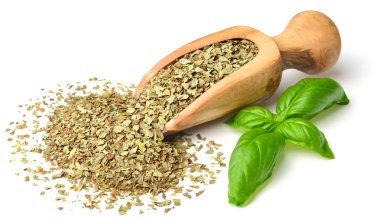 Kuru ot, ahşap kepçe içinde fesleğen yaprakları beyaz arka plan üzerinde izole