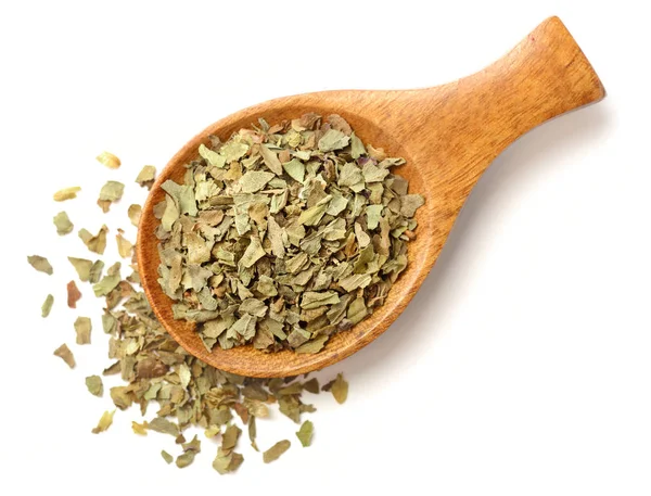 Beyaz arka plan üzerinde izole tahta kaşık kuru fesleğen yaprağı