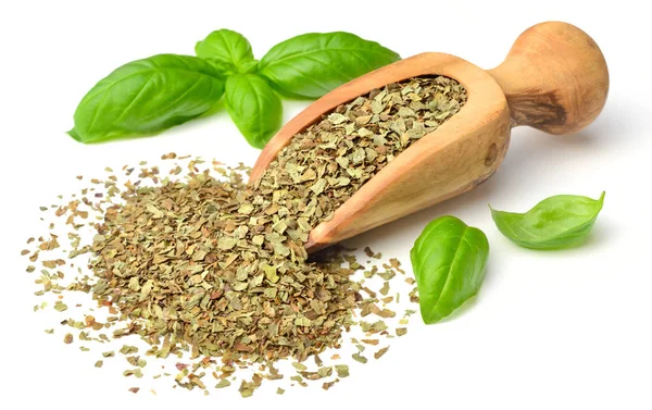 Kuru ot, ahşap kepçe içinde fesleğen yaprakları beyaz arka plan üzerinde izole