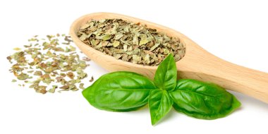 Beyaz arka plan üzerinde izole tahta kaşık kuru fesleğen yaprağı