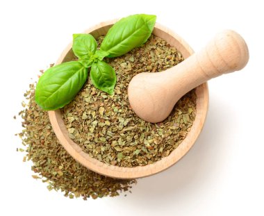 Beyaz arka plan üzerinde izole ahşap harç, kurutulmuş fesleğen