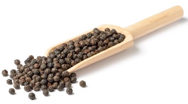 Beyaz arka plan üzerinde izole bütün karabiber ahşap kepçe içinde