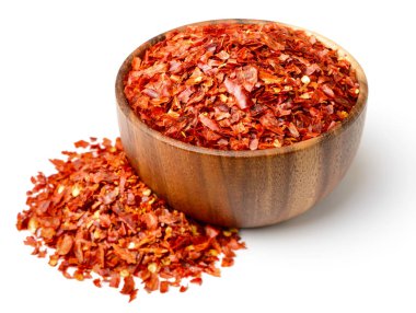 Beyaz arka plan üzerinde izole kırmızı biber pul ahşap kase kuru