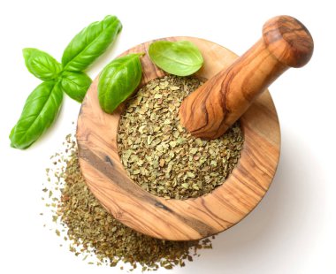 Kuru ot, ahşap harç içinde fesleğen yaprakları beyaz arka plan üzerinde izole