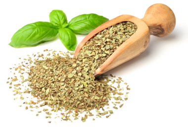 Kuru ot, ahşap kepçe içinde fesleğen yaprakları beyaz arka plan üzerinde izole