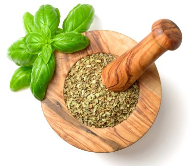 Kuru ot, ahşap harç içinde fesleğen yaprakları beyaz arka plan üzerinde izole