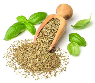 Kuru ot, ahşap kepçe içinde fesleğen yaprakları beyaz arka plan üzerinde izole