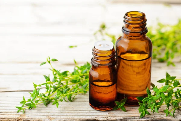 Kekik esans ve ahşap tahta üzerinde taze kekik