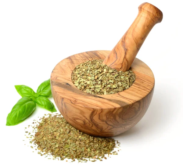 Kuru ot, ahşap harç içinde fesleğen yaprakları beyaz arka plan üzerinde izole