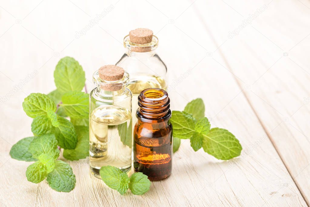 fresh mint essential oil on wooden board