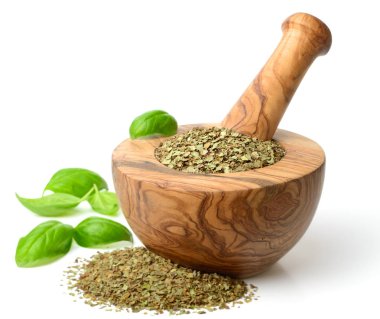 Kuru ot, ahşap harç içinde fesleğen yaprakları beyaz arka plan üzerinde izole