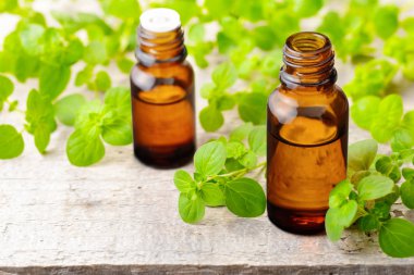 Kekik esans ve ahşap masa üzerinde taze kekik