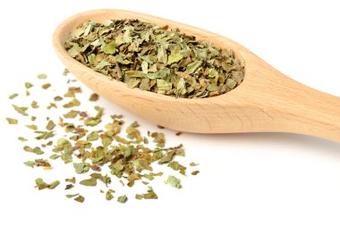 Beyaz arka plan üzerinde izole tahta kaşık kuru fesleğen yaprağı