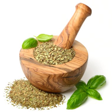 Kuru ot, ahşap harç içinde fesleğen yaprakları beyaz arka plan üzerinde izole