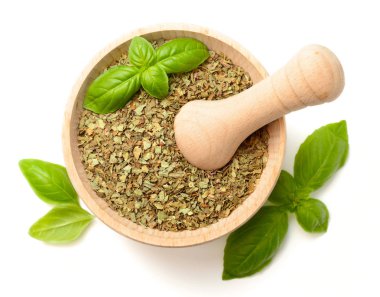 Beyaz arka plan üzerinde izole ahşap harç, kurutulmuş fesleğen