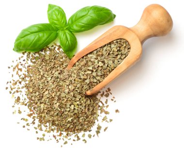 Kuru ot, ahşap kepçe içinde fesleğen yaprakları beyaz arka plan üzerinde izole