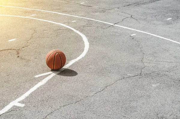 ball for playing basketball lies on the sports ground