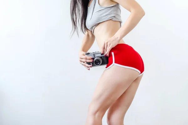 女の子 ほっそりした脚 腰のレベルで ビンテージ カメラを押し赤いショート パンツで — ストック写真