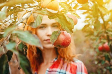 Kızıl saçlı kız portre için yaprak ve meyve bahçesinde