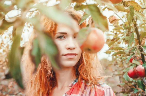 Κοκκινομάλλα κοπέλα πορτρέτο στον κήπο για τα φύλλα και τα φρούτα — Φωτογραφία Αρχείου