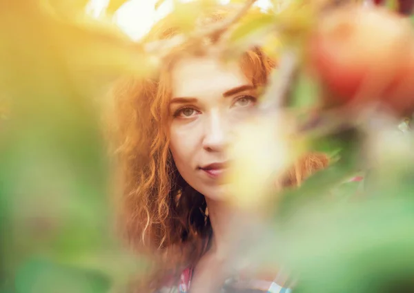 Portrait de fille aux cheveux roux dans le jardin pour les feuilles et les fruits — Photo