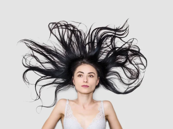 Frau Liegt Auf Hellem Hintergrund Mit Langen Wallenden Haaren — Stockfoto