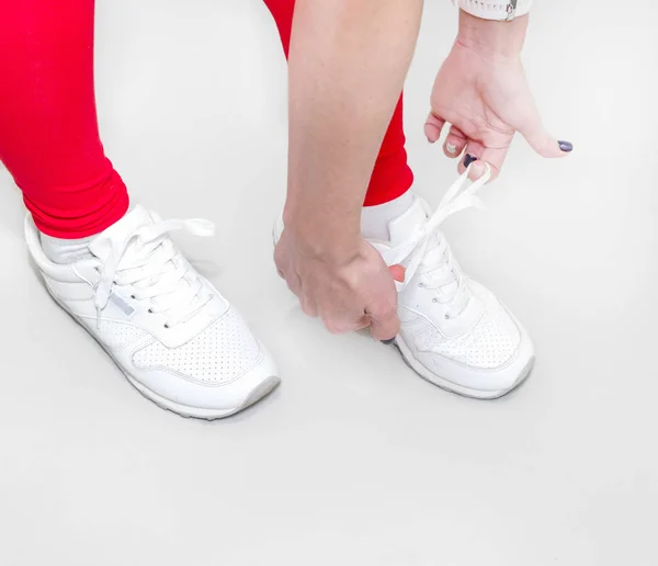 Chica Atando Zapatillas Blancas Sobre Fondo Claro — Foto de Stock