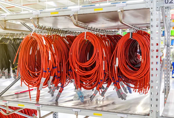 Coils of electrical wires for the automotive industry, suspended on racks on a modern industrial plant.