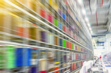 Endüstriyel bir tesisi büyük raflarda renkli elektrik telleri ile büyük bobinleri. Arabalar için elektrik tesisatı imalatı. Sektöründe istihdam