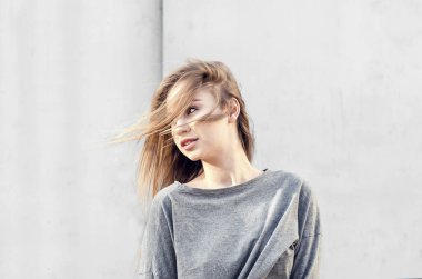 Rüzgar hafif bir arka planda çırpınan bir çekici genç sarışın kız portresi. Gençlik cinsellik. Bağımsız kız. Dinamik portre yakın çekim.