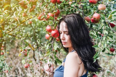 Seksi esmer bir yabani elma bahçesi içinde. Portre arka plan elma dalı. Kadın cinselliği. Yaz anıları. Stil Eve. Doğal