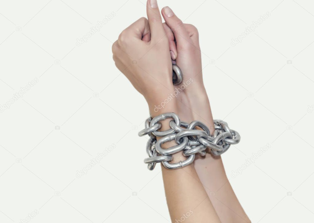 Thin hands woman bound thick shiny metal chain. Slavery, violence, bondage