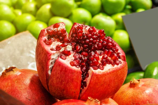 Cut pomegranate fruit on counter street market. Healthy food, vitamins, weight loss