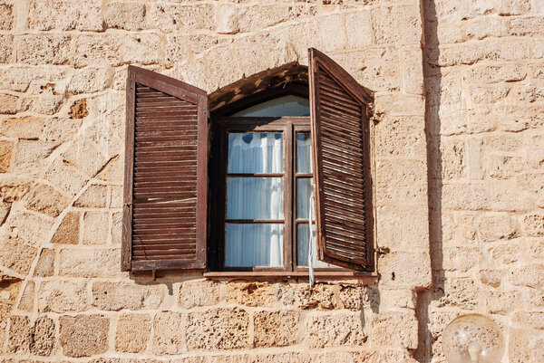 Old house in Israel with windows with brown shutters. Historical building.