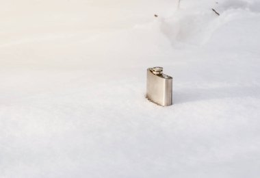 Alkol karda için metalik parlak şişesi. Doğa, kış, dinlenme.