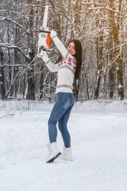 Kadın bir kazak ve kot pantolon bir chainsaw woods onun elinde tutar. Ormansızlaşma, testere, oduncu orman ürünleri.