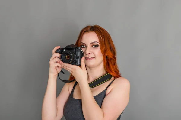 Smiling Woman Red Hair Holds Modern Camera Her Hands Gray — Stock Photo, Image