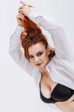 Güzel kadın ve karanlık sütyen beyaz arka planda, izole elleriyle kaldırdı saç, büyük göğüsler. Cinsellik, sağlık.