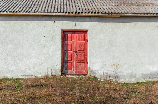 Piros ajtó zárt lakat egy régi elhagyatott épületben — Stock Fotó
