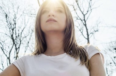 Bir kız, orman arka plan arka ışık yüzüne portresi