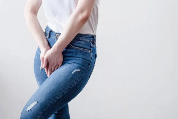 Jeune femme en jeans debout avec ses mains entre les jambes — Photo
