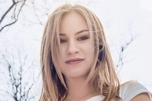 Portrait of a girl, face in back light on the background of the forest