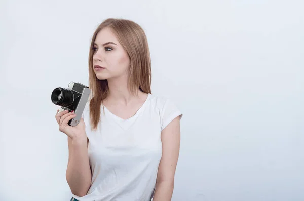 Ragazza attraente che tiene in mano una macchina fotografica vintage. Guardando un — Foto Stock