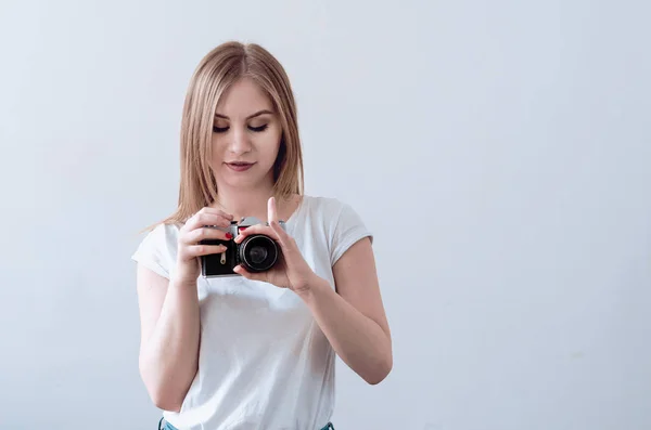 Attraente ragazza che tiene una fotocamera vintage tra le mani — Foto Stock