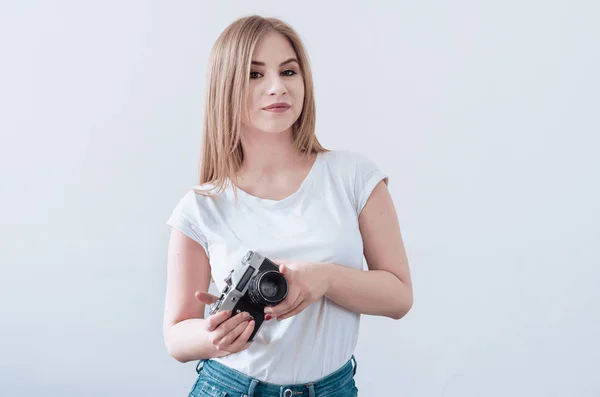 Menina atraente segurando uma câmera vintage em suas mãos — Fotografia de Stock