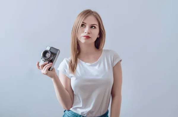 Atraktivní dívka držící vintage camera v její rukou. Confusedl — Stock fotografie