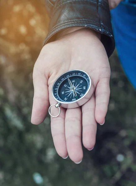 La brújula está en la mano de la chica. Dirección del horizonte —  Fotos de Stock