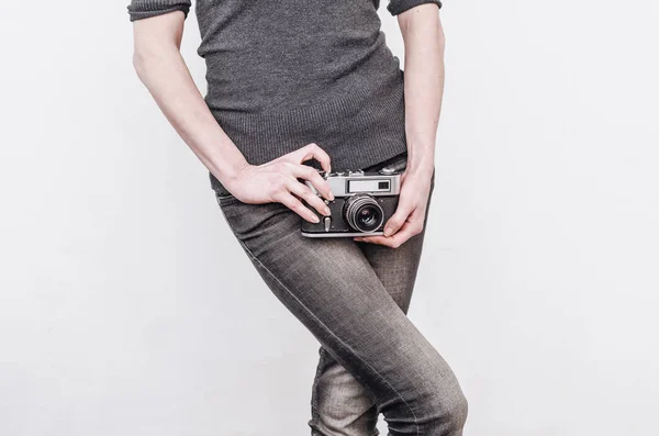 Menina em jeans detém uma velha câmera de filme vintage nos quadris . — Fotografia de Stock