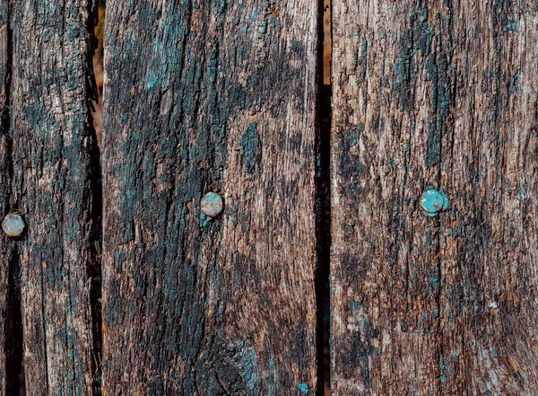 Старі дошки коричневого кольору пошкоджені фарбою і залишками болтів — стокове фото