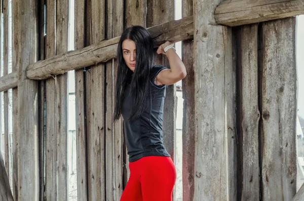Hermosa chica atlética joven en leggings rojos en el fondo — Foto de Stock